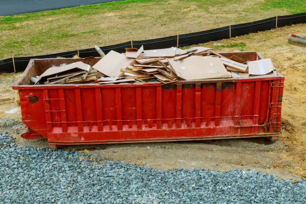 red dumpster being full with carton