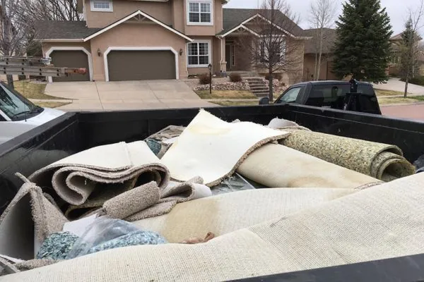 dumpster with old carpet inside